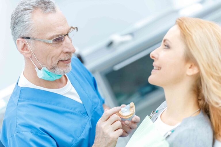 Dentist showing a tooth model to a patient.